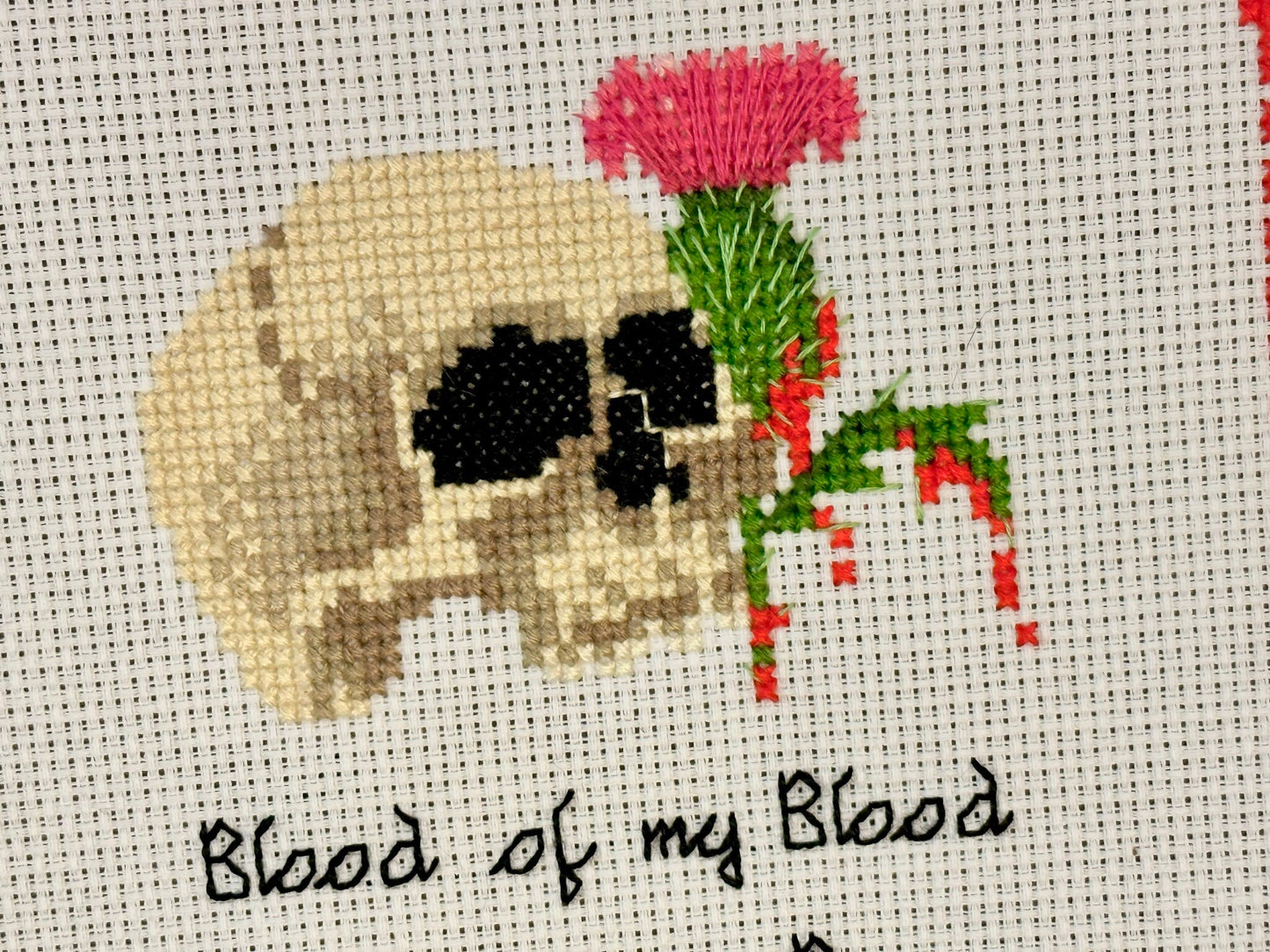 Human Skull with blood dripping from a Scottish thistle, cursive text that says Blood of my Blood, Bone of my Bone with the anniversary date centered below it.