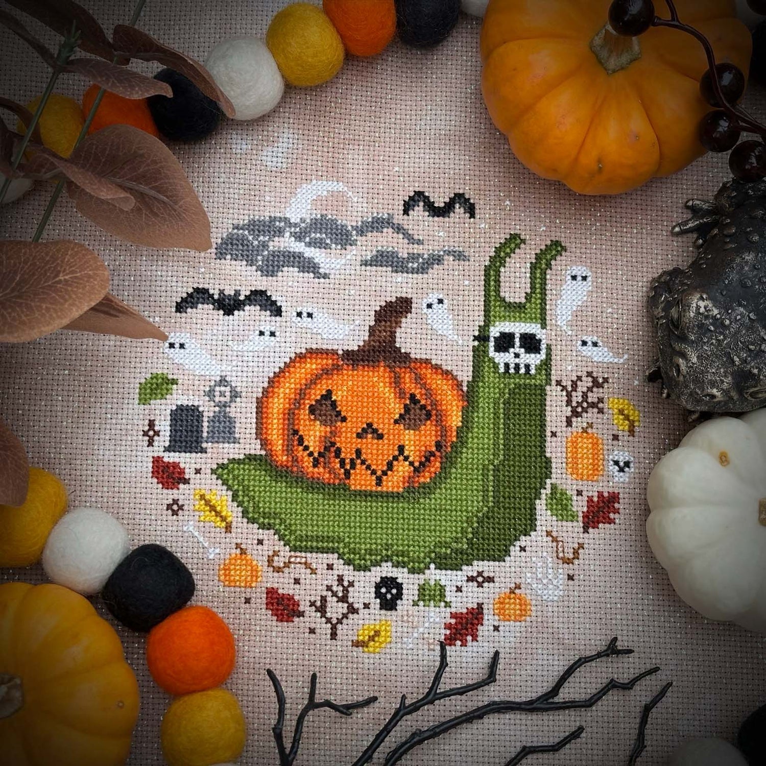 Haunted brick well with ghosts and a pumpkin, witches broom, and a lantern sitting next to it.